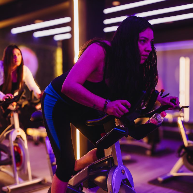 Iluminación inmersiva durante una clase de ciclismo indoor en LÚMINA
